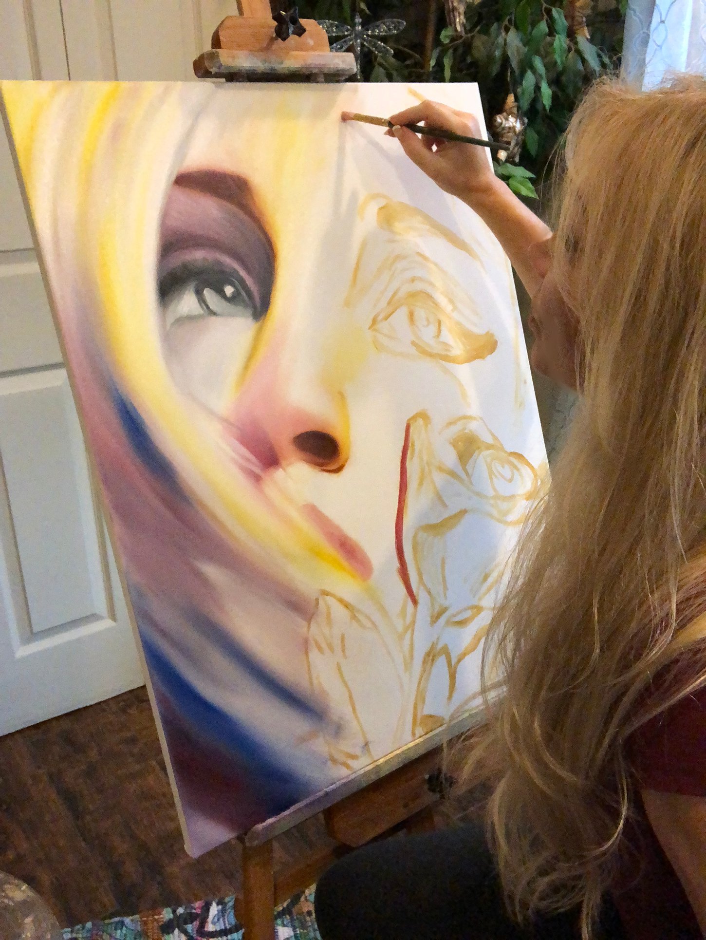 Portrait of Gina Mielko, contemporary surrealist artist working in her studio